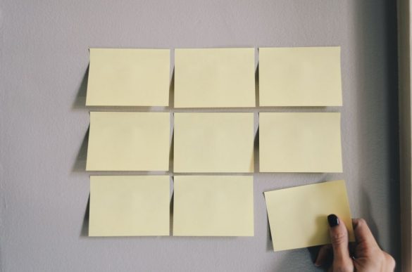 9 żółtych karteczek post-it na szarym tle